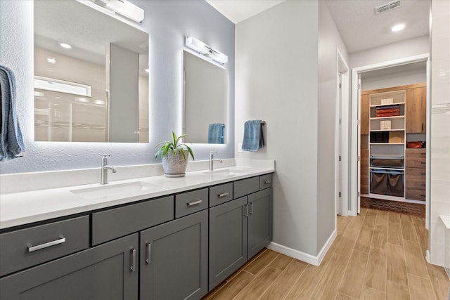 full bathroom featuring visible vents, wood finish floors, and a sink