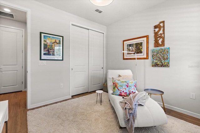 sitting room featuring baseboards, visible vents, and wood finished floors