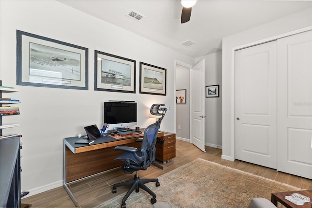 office area featuring ceiling fan, baseboards, visible vents, and wood finished floors