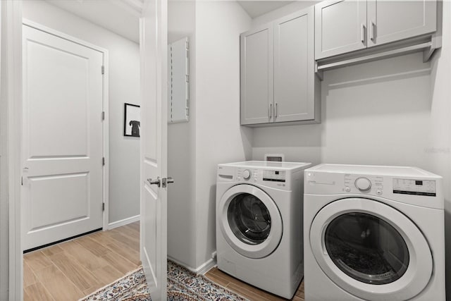 laundry area with cabinet space, washing machine and dryer, light wood-style flooring, and baseboards