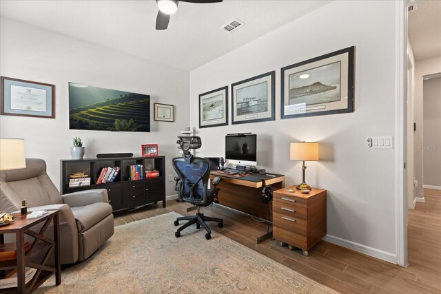 office with baseboards, visible vents, ceiling fan, and wood finished floors
