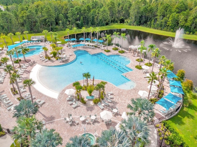 pool with a patio area and a view of trees