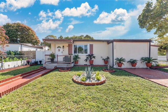 ranch-style house with a front yard, fence, and stucco siding