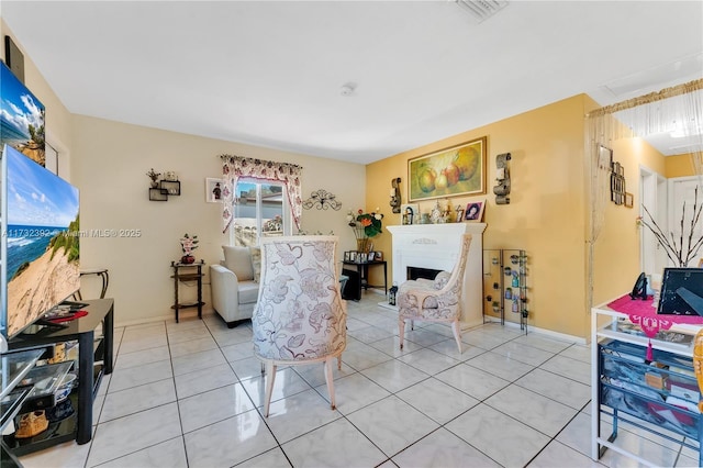 living room featuring visible vents, light tile patterned flooring, and a fireplace
