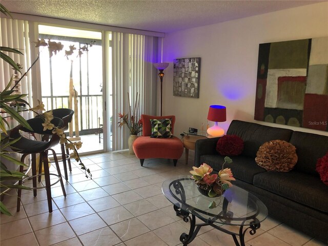 25806 Cockleshell Dr Unit 314, Bonita Springs, FL 34135 - living room featuring expansive windows, a textured ceiling, and light tile patterned floors
