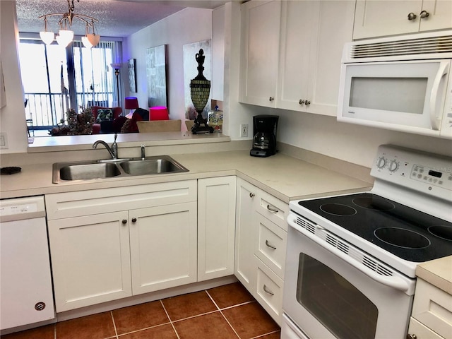 25806 Cockleshell Dr Unit 314, Bonita Springs, FL 34135 - kitchen featuring white cabinets, light countertops, a sink, and white appliances