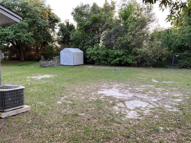 view of yard with central AC unit, an outdoor structure, and a shed