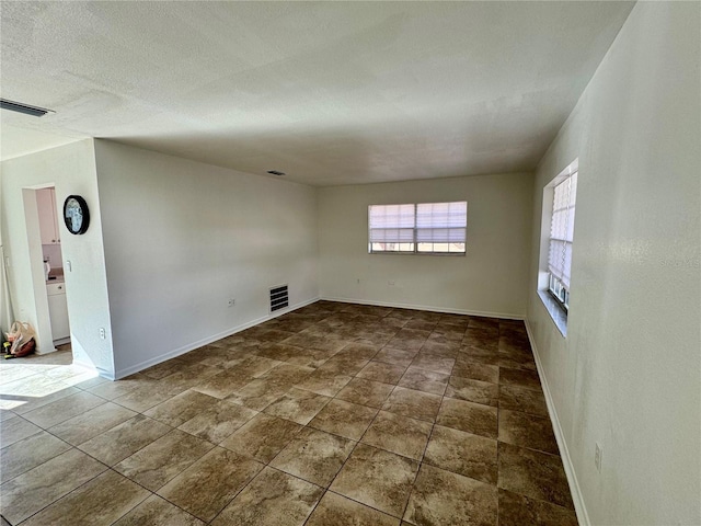 spare room featuring baseboards and visible vents