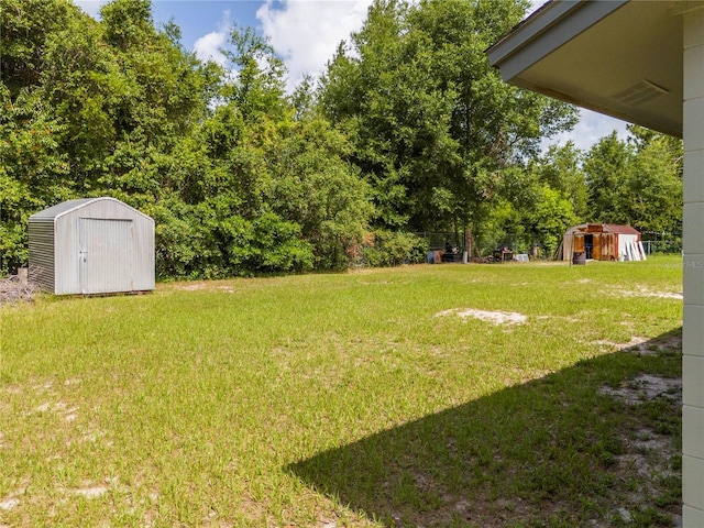 14796 SW 39th Cir, Ocala, FL 34473 - view of grassy yard featuring a storage unit and view of wooded area
