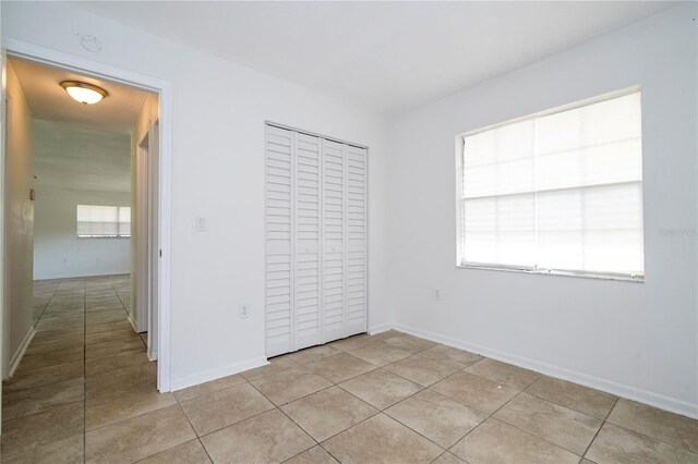 14796 SW 39th Cir, Ocala, FL 34473 - unfurnished bedroom with light tile patterned floors, multiple windows, and a closet
