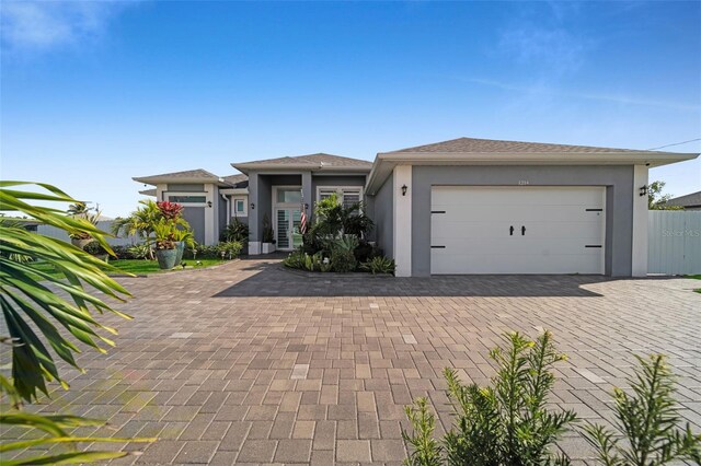1214 Embers Pkwy W, Cape Coral, FL 33993 - prairie-style home with an attached garage, decorative driveway, and stucco siding