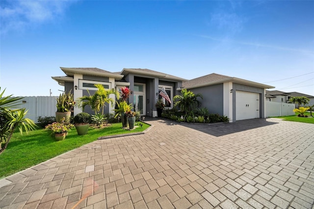 1214 Embers Pkwy W, Cape Coral, FL 33993 - prairie-style house featuring fence, stucco siding, decorative driveway, and an attached garage