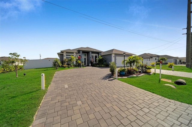 1214 Embers Pkwy W, Cape Coral, FL 33993 - prairie-style house featuring a garage, a front yard, fence, and decorative driveway