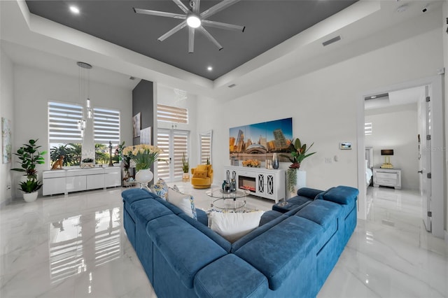 1214 Embers Pkwy W, Cape Coral, FL 33993 - living area with a towering ceiling, a ceiling fan, visible vents, a raised ceiling, and marble finish floor