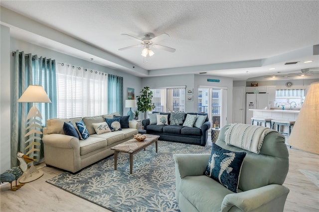 5300 S Atlantic Ave Unit 2-501, New Smyrna Beach, FL 32169 - living room featuring light wood-style flooring, a textured ceiling, and a ceiling fan