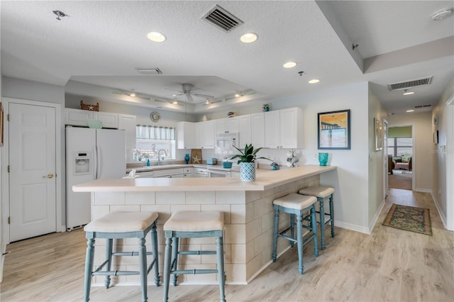 5300 S Atlantic Ave Unit 2-501, New Smyrna Beach, FL 32169 - kitchen featuring white appliances, visible vents, a breakfast bar area, and a peninsula