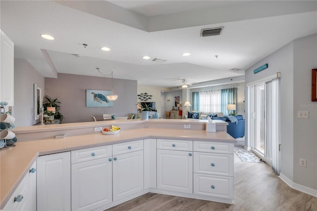 5300 S Atlantic Ave Unit 2-501, New Smyrna Beach, FL 32169 - kitchen featuring visible vents, white cabinets, open floor plan, light countertops, and light wood-type flooring