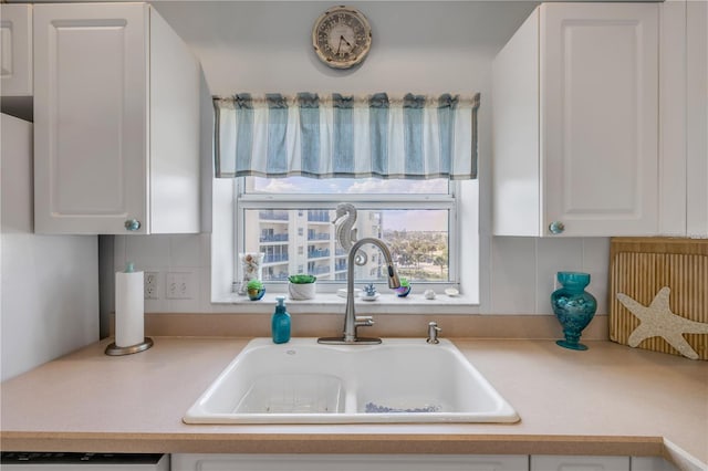 5300 S Atlantic Ave Unit 2-501, New Smyrna Beach, FL 32169 - kitchen with tasteful backsplash, light countertops, white cabinetry, dishwashing machine, and a sink