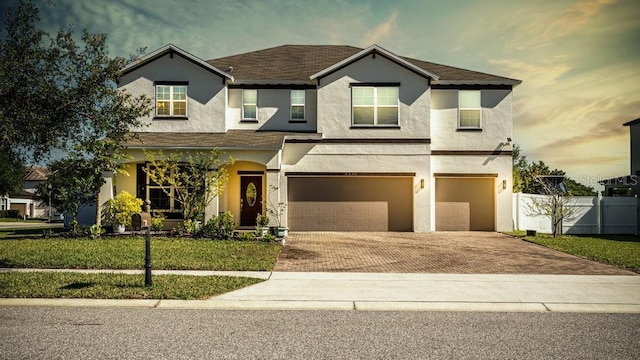 3556 Cheswick Dr, Ocoee, FL 34761 - view of front of property with a front yard, an attached garage, fence, stucco siding, and decorative driveway