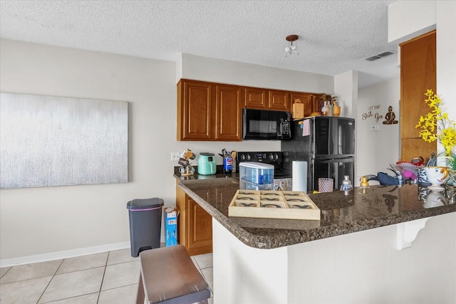 1065 S Hiawassee Rd Unit 1436, Orlando, FL 32835 - kitchen featuring a kitchen breakfast bar, brown cabinets, light tile patterned floors, black appliances, and a peninsula