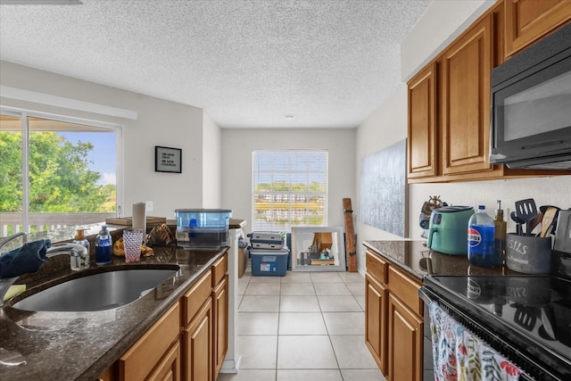 1065 S Hiawassee Rd Unit 1436, Orlando, FL 32835 - kitchen with brown cabinetry, a sink, and black appliances
