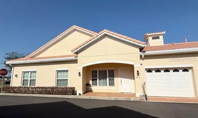 mediterranean / spanish-style house featuring a garage and stucco siding