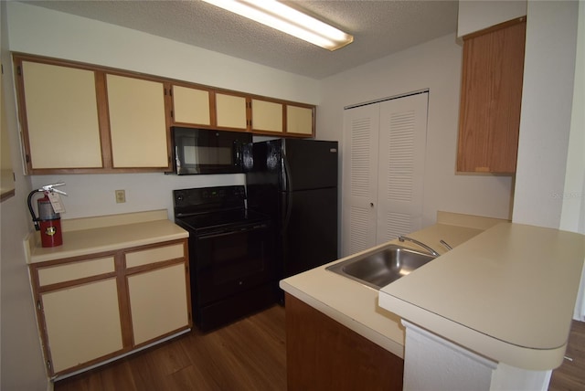 1075 S Hiawassee Rd Unit 916, Orlando, FL 32835 - kitchen featuring a peninsula, black appliances, dark wood-style flooring, light countertops, and a sink