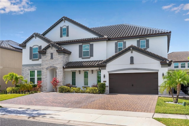 8109 Ludington Cir, Orlando, FL 32836 - mediterranean / spanish home with stucco siding, stone siding, a tile roof, and decorative driveway