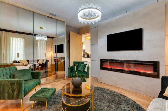 8109 Ludington Cir, Orlando, FL 32836 - living room with a chandelier, a glass covered fireplace, visible vents, and light wood-style flooring