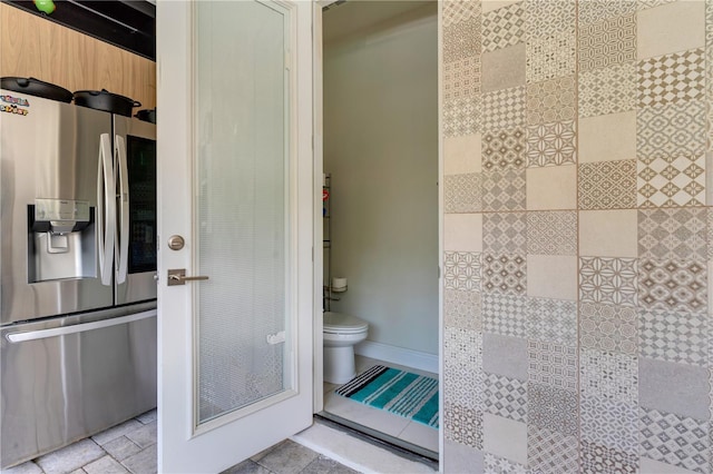 8109 Ludington Cir, Orlando, FL 32836 - bathroom featuring stone tile flooring, baseboards, and toilet