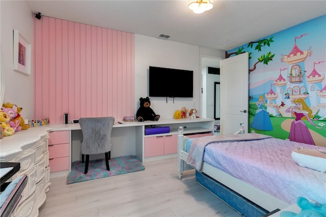8109 Ludington Cir, Orlando, FL 32836 - bedroom featuring built in study area, visible vents, light wood-type flooring, and a textured ceiling
