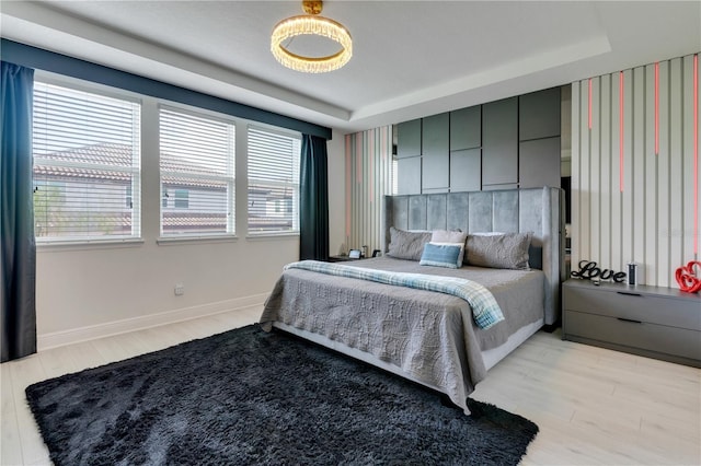 8109 Ludington Cir, Orlando, FL 32836 - bedroom featuring a tray ceiling, light wood-style flooring, and baseboards