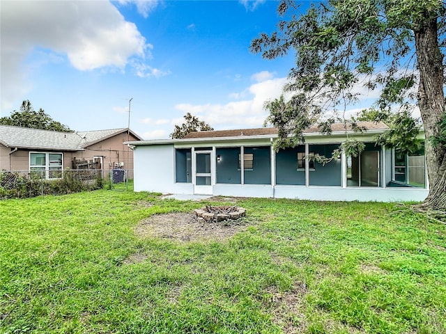 7400 Mitchell Ranch Rd, New Port Richey, FL 34655 - back of property featuring a sunroom, an outdoor fire pit, and stucco siding