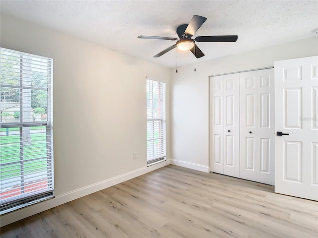 7400 Mitchell Ranch Rd, New Port Richey, FL 34655 - unfurnished bedroom featuring light wood-style floors, baseboards, a closet, and ceiling fan