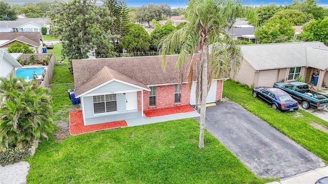 7400 Mitchell Ranch Rd, New Port Richey, FL 34655 - view of front of property featuring driveway, a shingled roof, brick siding, and a garage