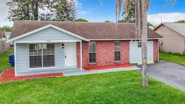 7400 Mitchell Ranch Rd, New Port Richey, FL 34655 - view of front of property featuring a shingled roof, a front lawn, and brick siding