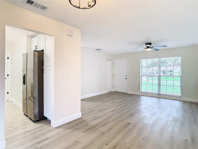 7400 Mitchell Ranch Rd, New Port Richey, FL 34655 - spare room with light wood finished floors, a ceiling fan, baseboards, and a textured ceiling