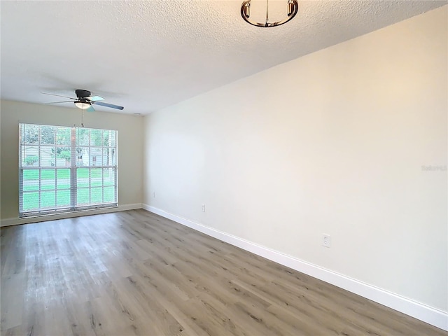 7400 Mitchell Ranch Rd, New Port Richey, FL 34655 - spare room with wood finished floors, a ceiling fan, baseboards, and a textured ceiling
