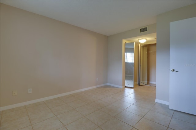spare room with light tile patterned floors, baseboards, and visible vents