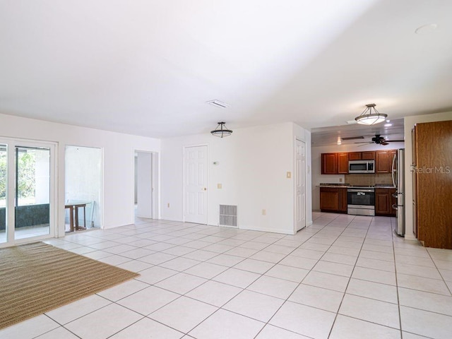 unfurnished living room with light tile patterned floors, visible vents, baseboards, and a ceiling fan