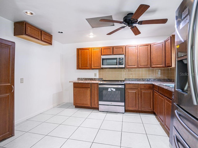 kitchen featuring ceiling fan, light tile patterned floors, brown cabinetry, tasteful backsplash, and stainless steel appliances