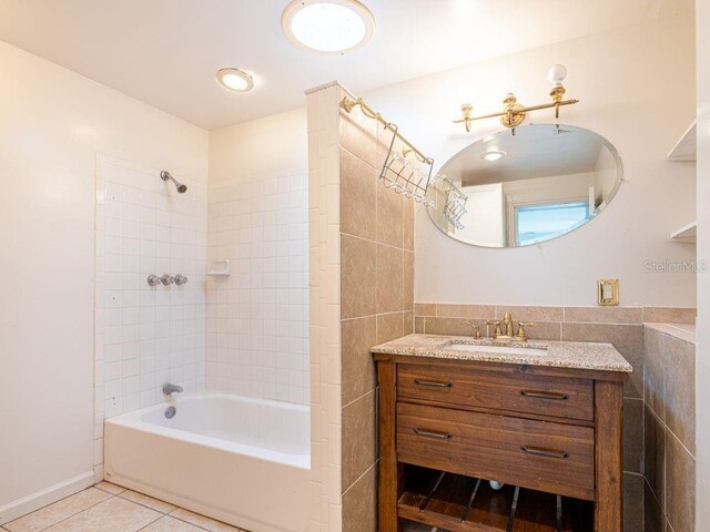 full bathroom featuring tile patterned floors, vanity, washtub / shower combination, and tile walls