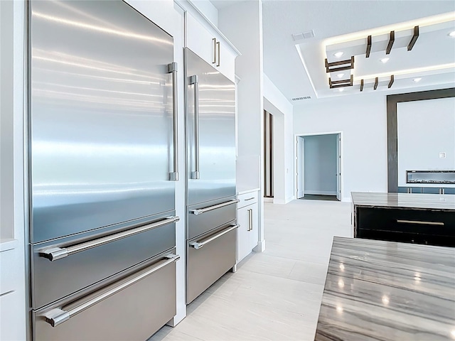 1080 E Jack Nicklaus Ct, Kissimmee, FL 34747 - kitchen featuring stainless steel built in refrigerator, a raised ceiling, white cabinets, and light countertops