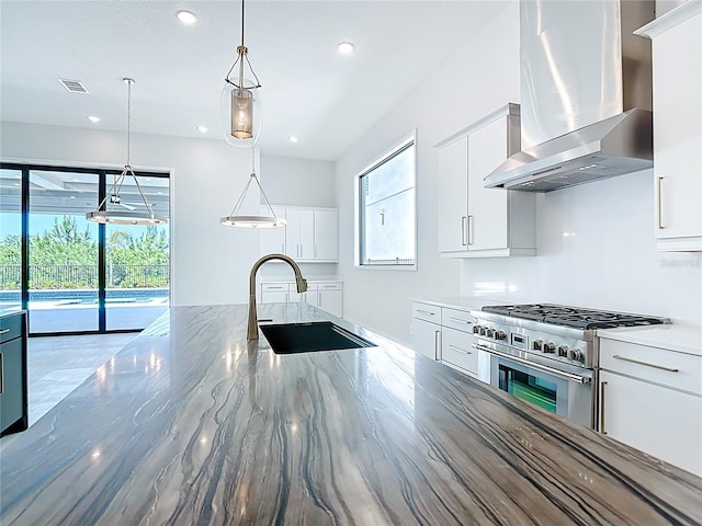 1080 E Jack Nicklaus Ct, Kissimmee, FL 34747 - kitchen with wall chimney range hood, high end stainless steel range, a sink, recessed lighting, and hanging light fixtures