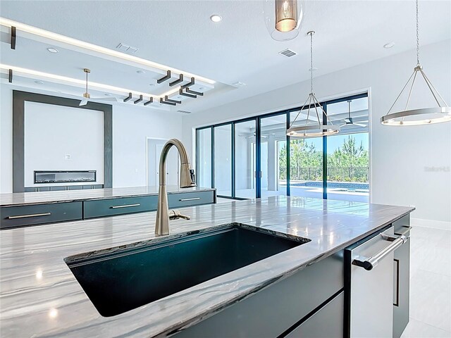 1080 E Jack Nicklaus Ct, Kissimmee, FL 34747 - kitchen featuring a sink, light stone countertops, pendant lighting, baseboards, and recessed lighting