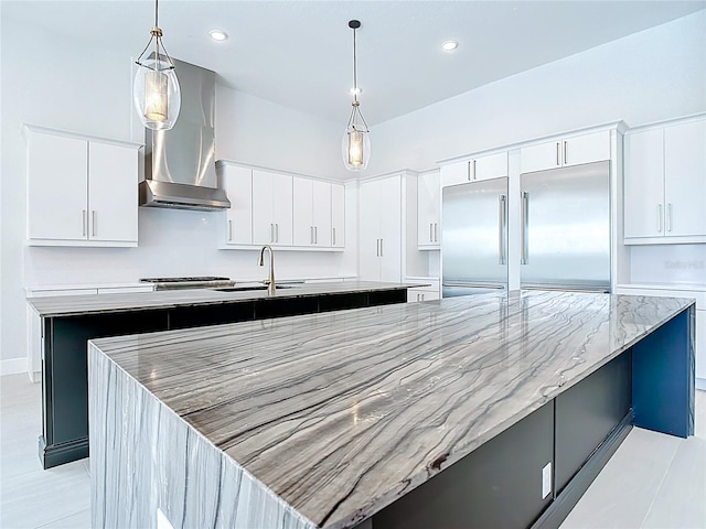 1080 E Jack Nicklaus Ct, Kissimmee, FL 34747 - kitchen featuring a spacious island, built in fridge, wall chimney range hood, a sink, and pendant lighting