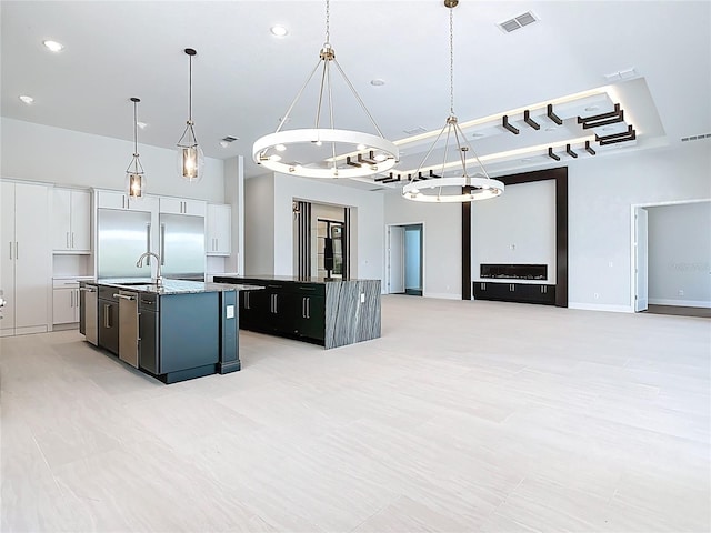 1080 E Jack Nicklaus Ct, Kissimmee, FL 34747 - kitchen featuring an island with sink, a sink, pendant lighting, open floor plan, and a chandelier