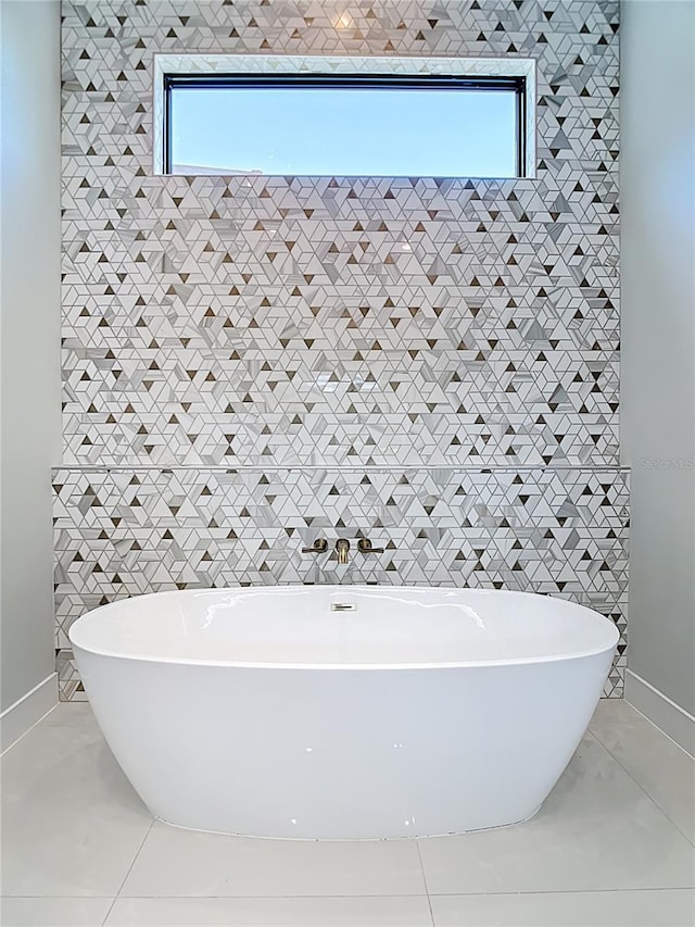 1080 E Jack Nicklaus Ct, Kissimmee, FL 34747 - full bathroom featuring tile patterned floors, a freestanding tub, baseboards, and tile walls