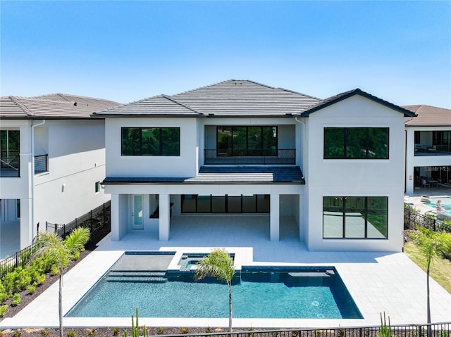 1080 E Jack Nicklaus Ct, Kissimmee, FL 34747 - rear view of property featuring stucco siding, a patio area, an in-ground hot tub, a balcony, and a tiled roof