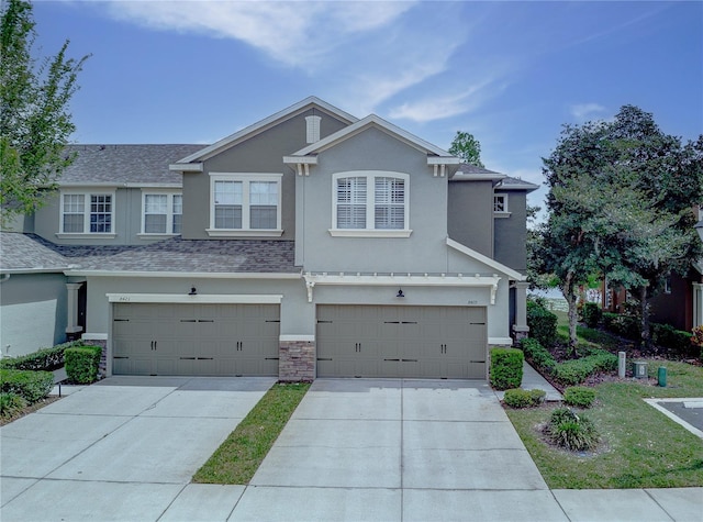 8419 Chamberlain Pl, Oviedo, FL 32765 - view of front of home featuring stucco siding, driveway, stone siding, a garage, and a shingled roof